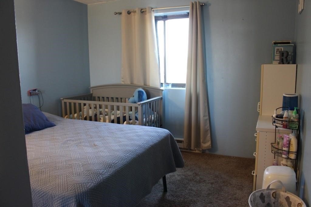 10 Main Street, Unit 507 Framingham, MA 01702 - Photo 12 of 17 a bedroom with a bed and a window