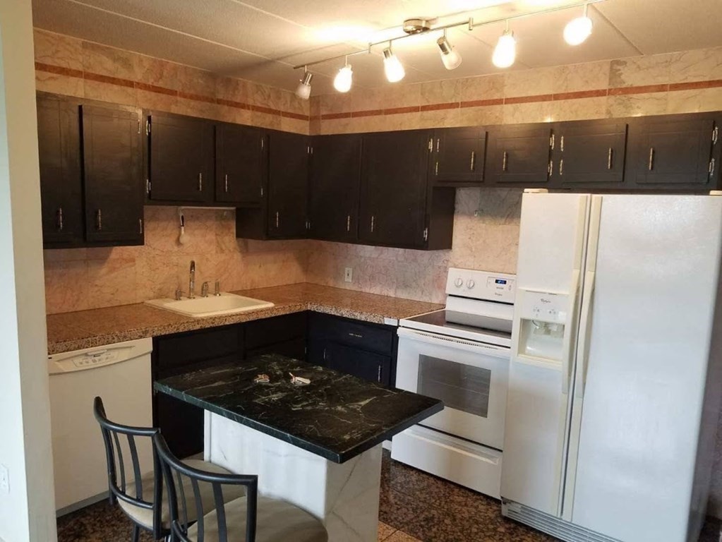 10 Main Street, Unit 507 Framingham, MA 01702 - Photo 16 of 17 a kitchen with a sink a stove and cabinets