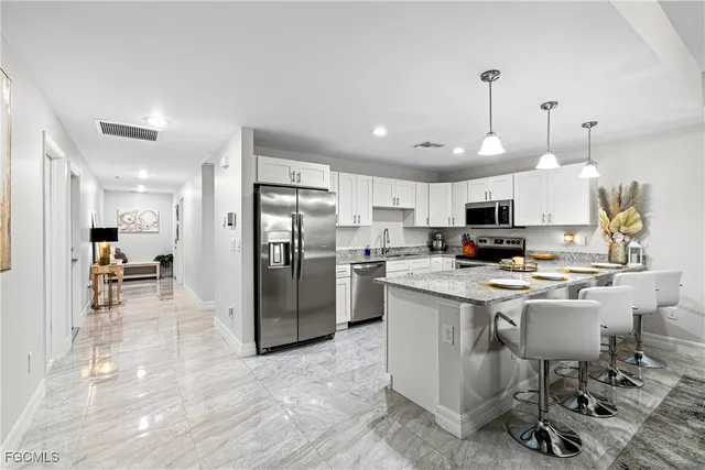 a kitchen with a sink a counter top stainless steel appliances and cabinets