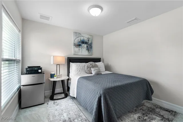 a bedroom with a bed and a refrigerator