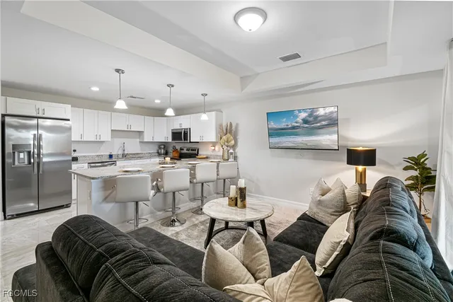 a living room with furniture and kitchen view