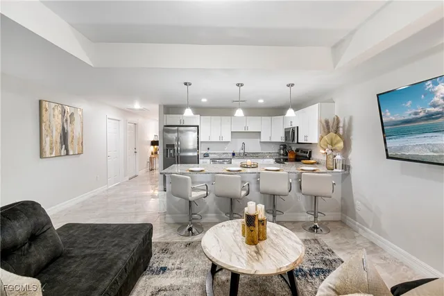 a living room with lots of furniture and kitchen view