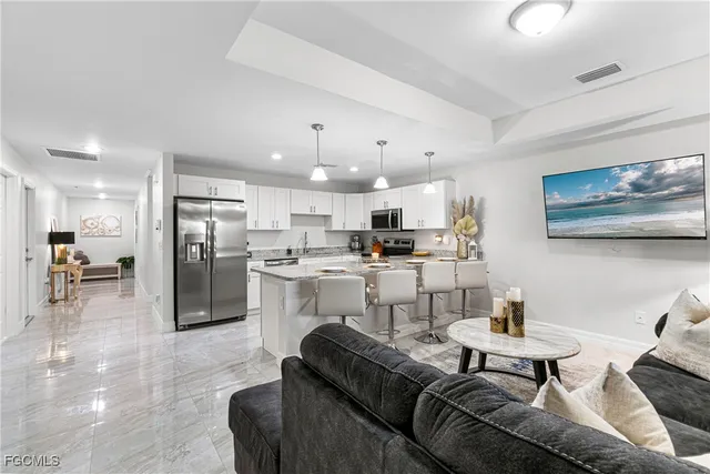 a living room with furniture and kitchen view