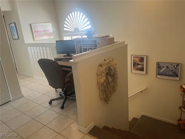 a view of a workspace with furniture and a window