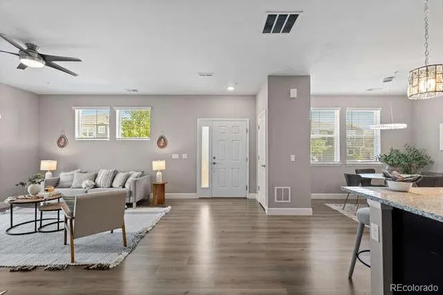 a living room with furniture and a wooden floor