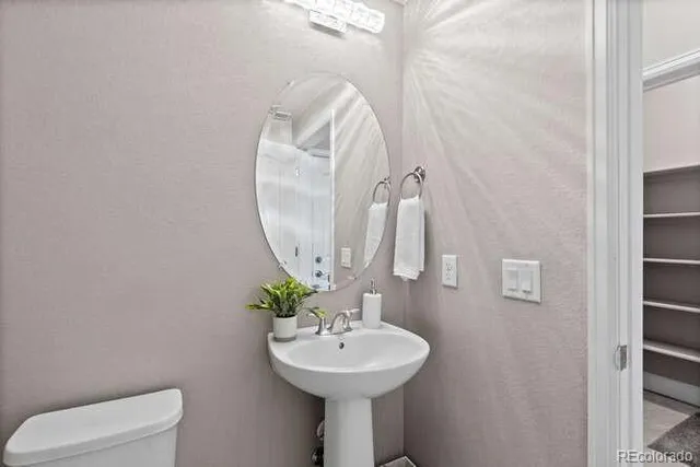 a bathroom with a sink a toilet and a mirror