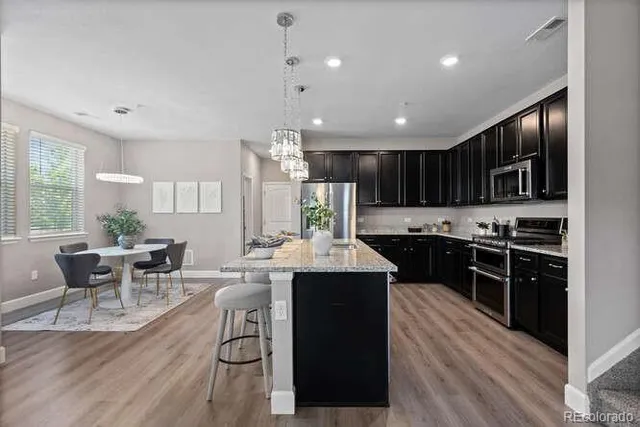 a large kitchen with kitchen island a sink a stove a dining table and chairs