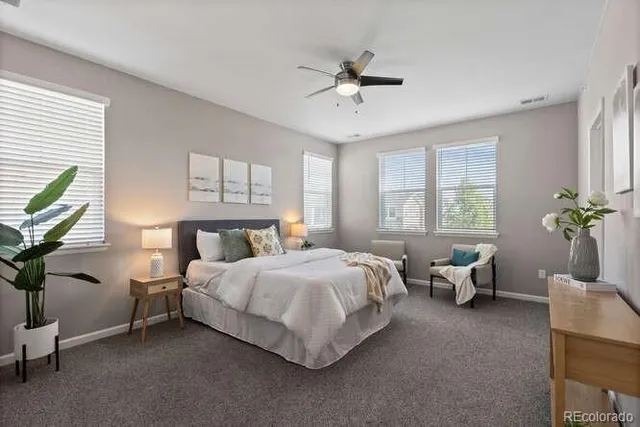 a spacious bedroom with a bed couch and a window