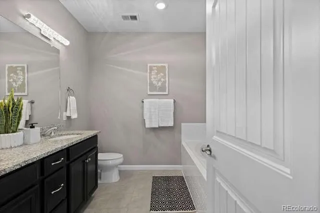 a bathroom with a sink a toilet mirror and vanity