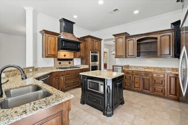 a kitchen with stainless steel appliances granite countertop a stove and a microwave
