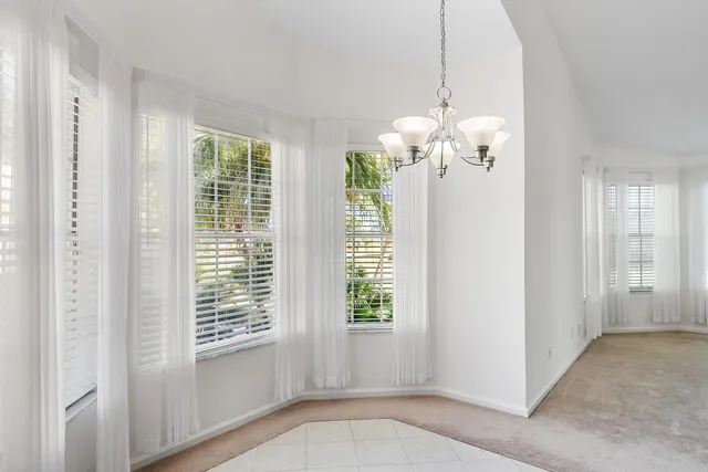 a view of a livingroom with a chandelier fan and windows