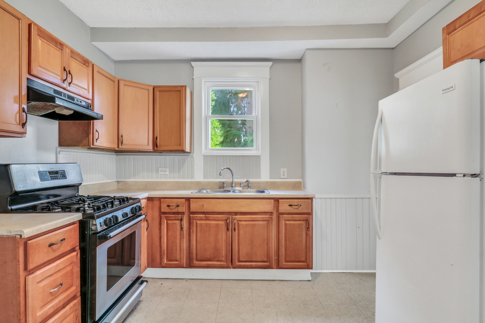 725 18th Street North Chicago, IL 60064 - Photo 12 of 32 a kitchen with stainless steel appliances granite countertop a stove a sink and a refrigerator