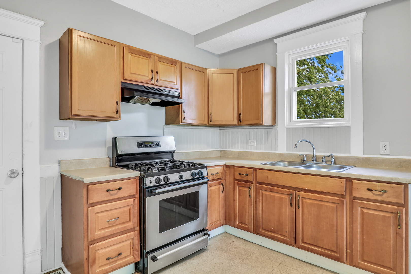 725 18th Street North Chicago, IL 60064 - Photo 13 of 32 a kitchen with cabinets appliances and a window