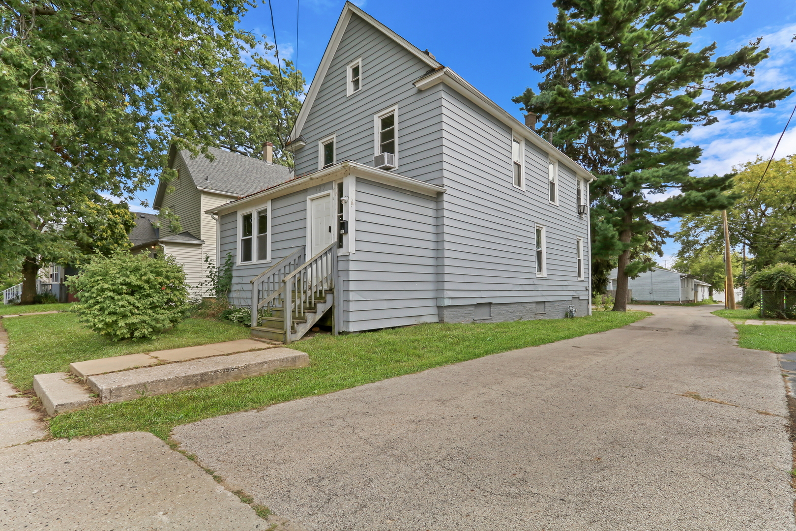 725 18th Street North Chicago, IL 60064 - Photo 30 of 32 a view of a white house with a yard and large trees