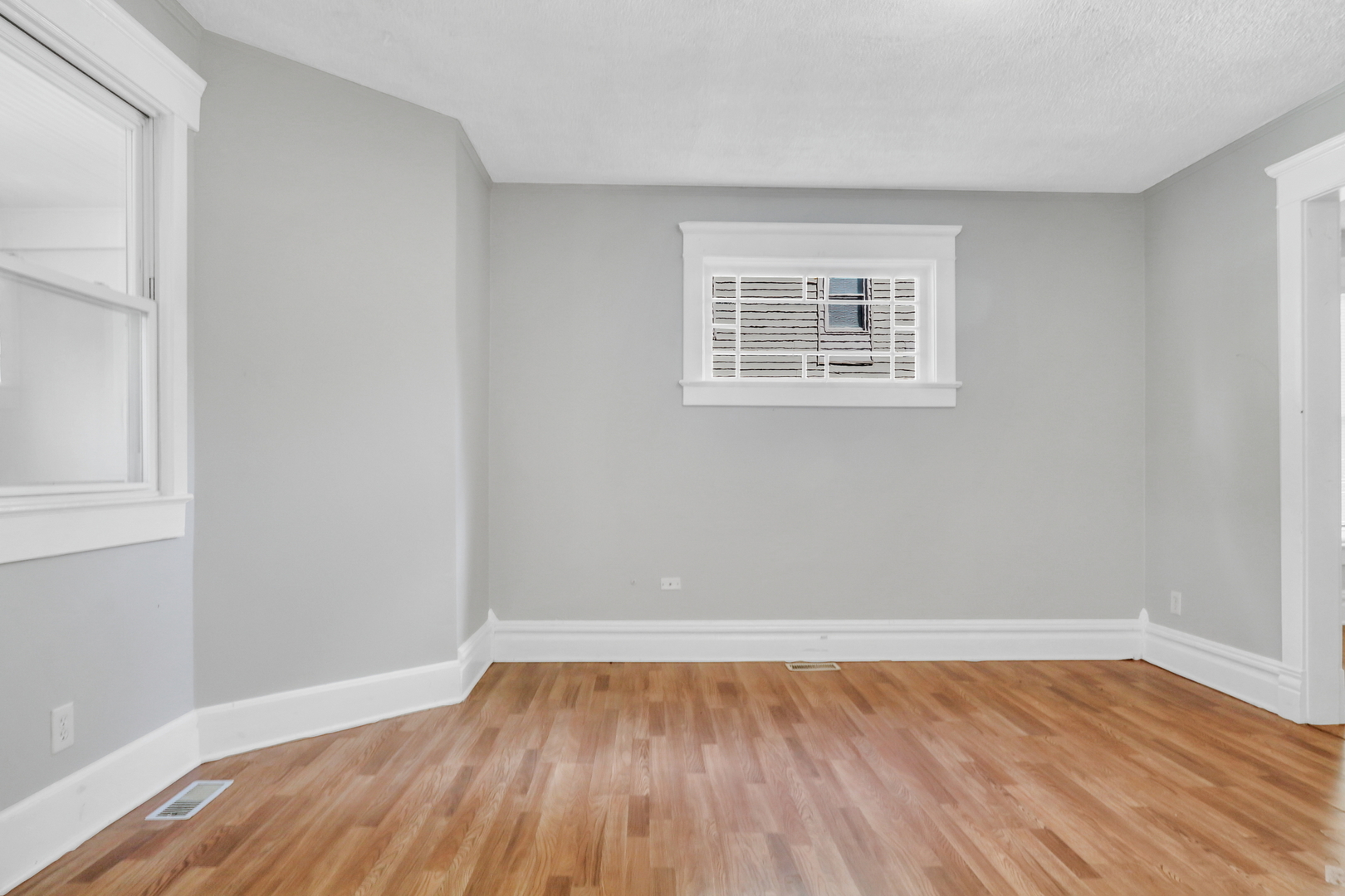725 18th Street North Chicago, IL 60064 - Photo 6 of 32 a view of an empty room with wooden floor and a window