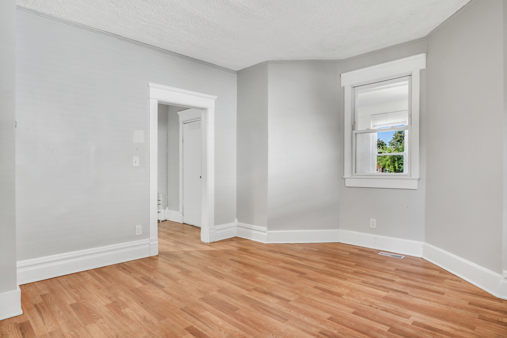 725 18th Street North Chicago, IL 60064 - Photo 7 of 32 a view of an empty room with wooden floor and a window