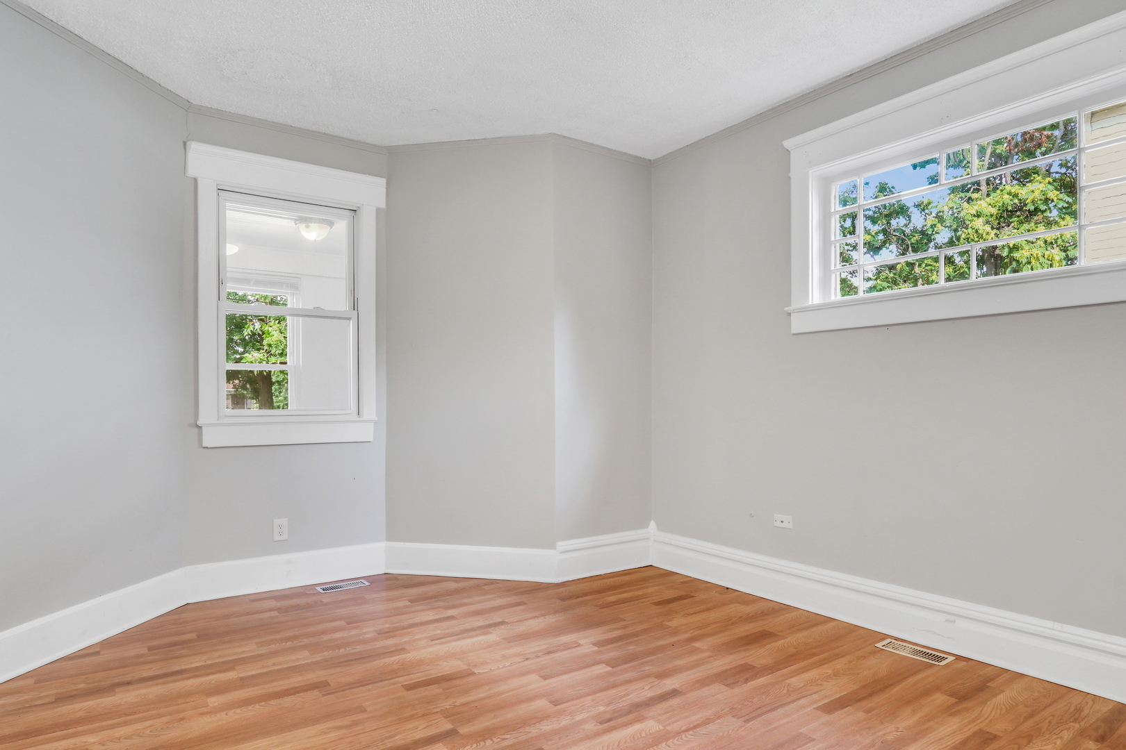 725 18th Street North Chicago, IL 60064 - Photo 9 of 32 a view of an empty room with wooden floor and a window