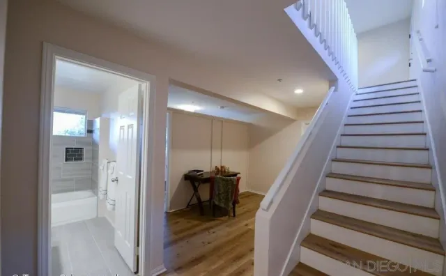 a view of a hallway with wooden floor and staircase
