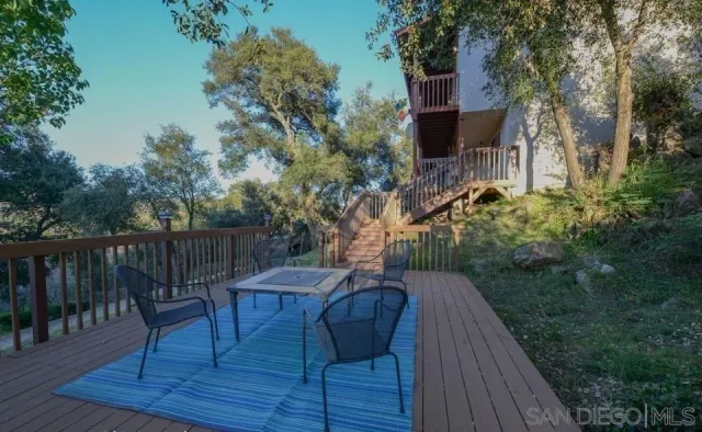 a backyard of a house with wooden floor and outdoor seating