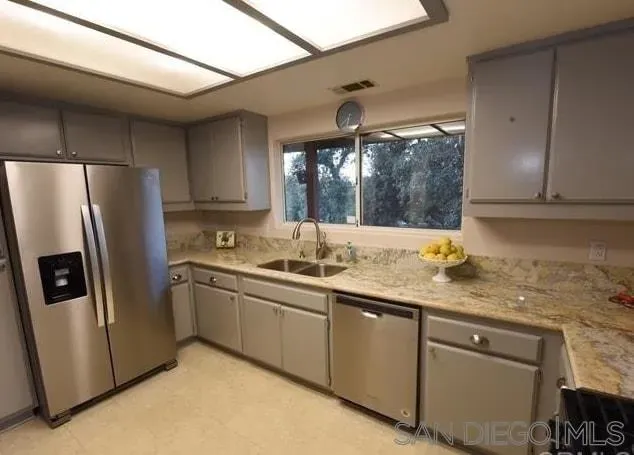 a kitchen with stainless steel appliances granite countertop a refrigerator and a sink