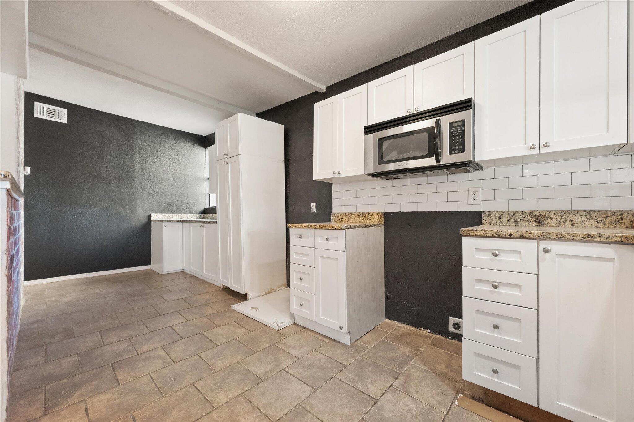 69 Pony Express Trail Lubbock, TX 79404 - Photo 15 of 39 a kitchen with white cabinets and stainless steel appliances
