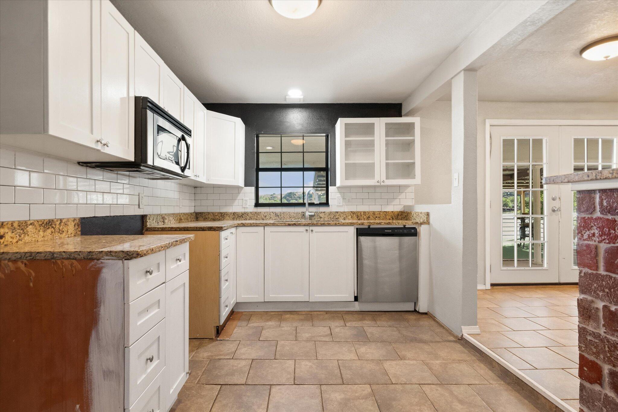 69 Pony Express Trail Lubbock, TX 79404 - Photo 19 of 39 a kitchen with stainless steel appliances granite countertop a stove and a sink