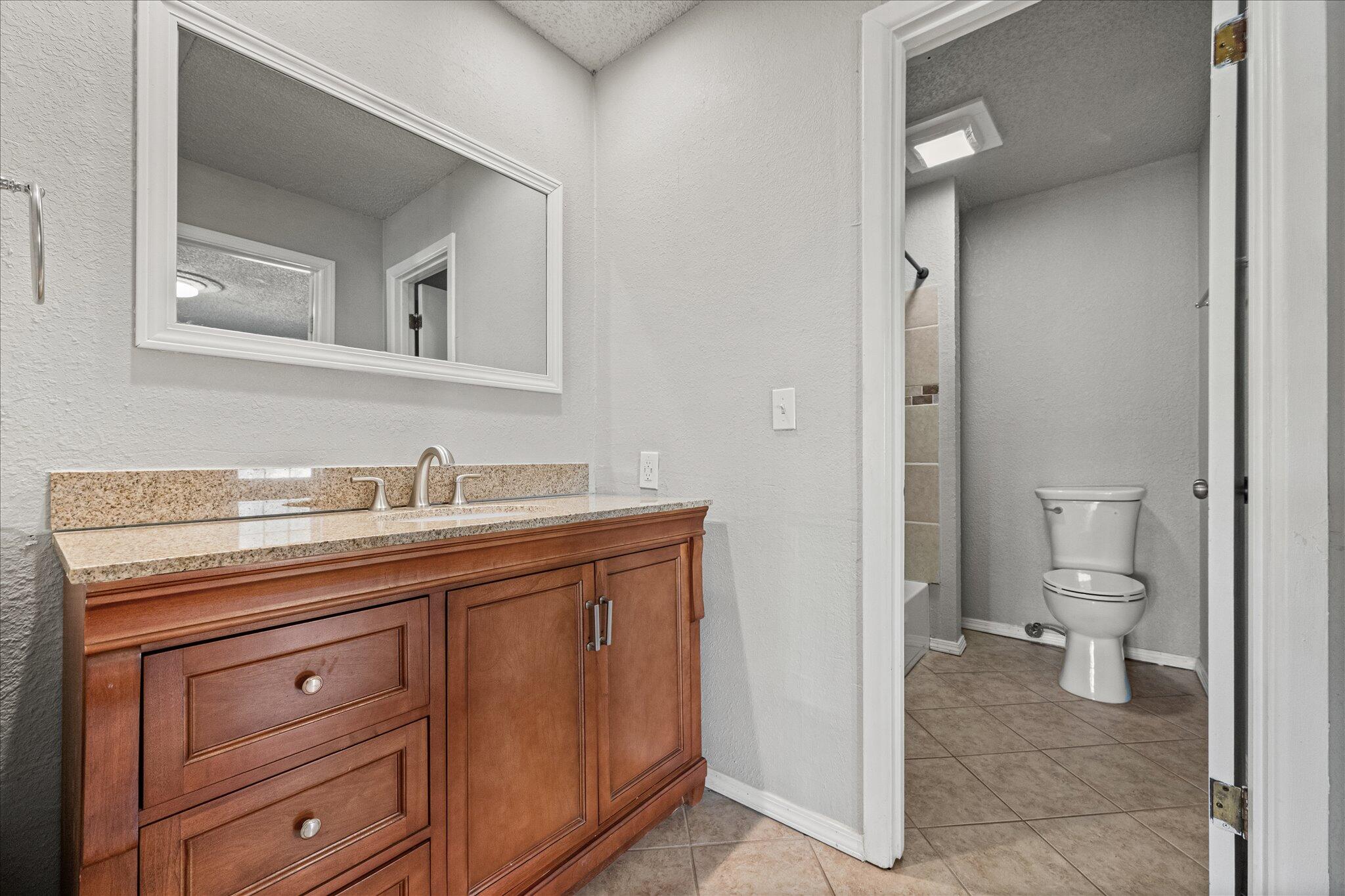 69 Pony Express Trail Lubbock, TX 79404 - Photo 24 of 39 a bathroom with a toilet sink and mirror