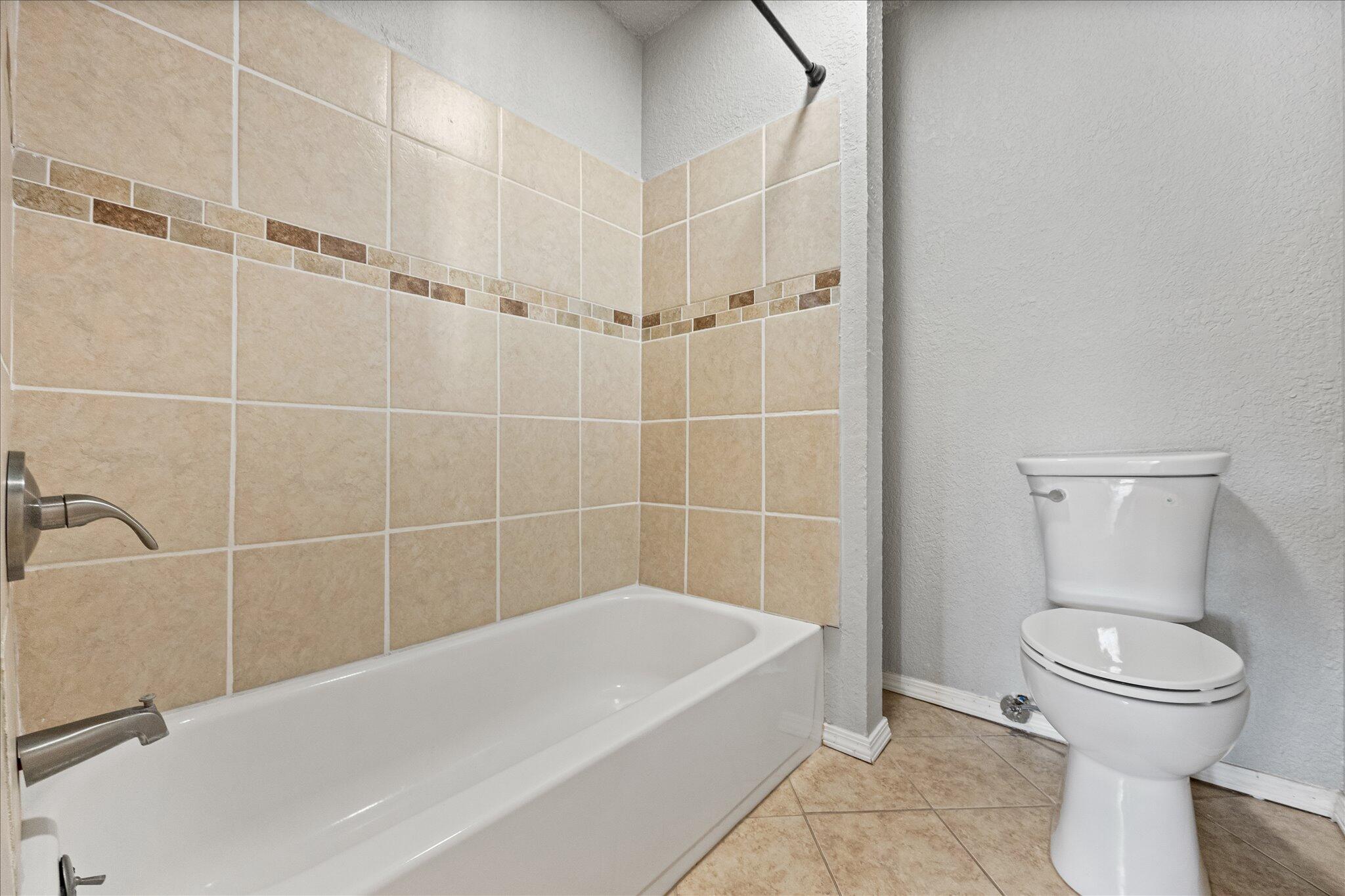 69 Pony Express Trail Lubbock, TX 79404 - Photo 32 of 39 a white bath tub sitting next to a toilet