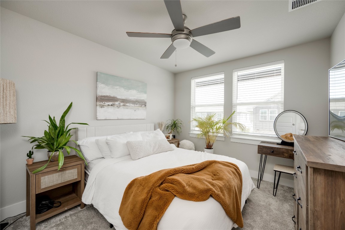 7502 Chesapeake Rail Lane, Unit 154 Austin, TX 78744 - Photo 24 of 40 a bedroom with a bed and a potted plant