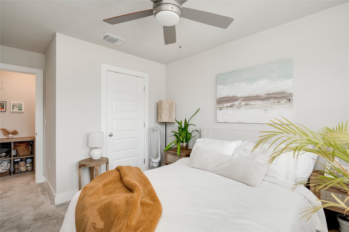 7502 Chesapeake Rail Lane, Unit 154 Austin, TX 78744 - Photo 25 of 40 a bedroom with a bed and ceiling fan