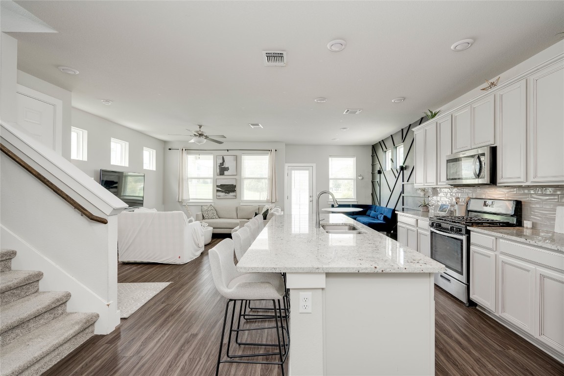 7502 Chesapeake Rail Lane, Unit 154 Austin, TX 78744 - Photo 3 of 40 a large kitchen with cabinets a sink a window and stainless steel appliances