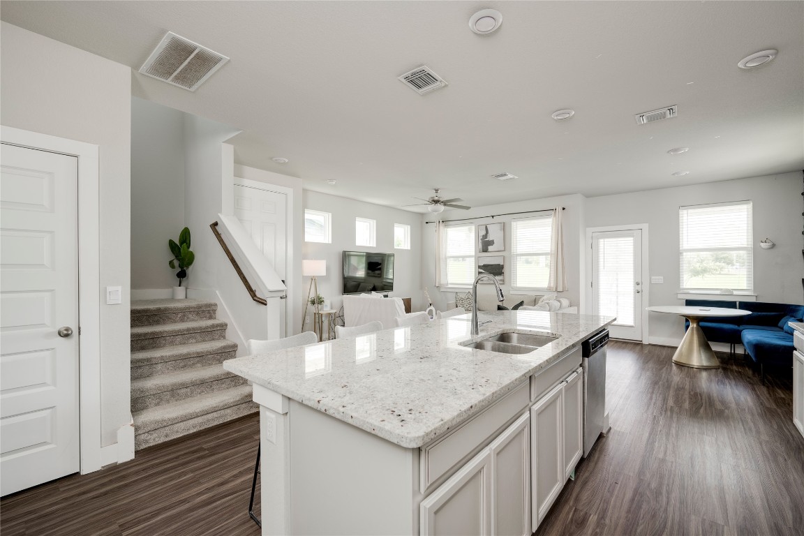 7502 Chesapeake Rail Lane, Unit 154 Austin, TX 78744 - Photo 4 of 40 a kitchen with granite countertop kitchen island stainless steel appliances a table and chairs