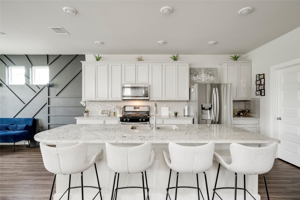 7502 Chesapeake Rail Lane, Unit 154 Austin, TX 78744 - Photo 5 of 40 a kitchen with stainless steel appliances kitchen island granite countertop a kitchen island and chairs in it