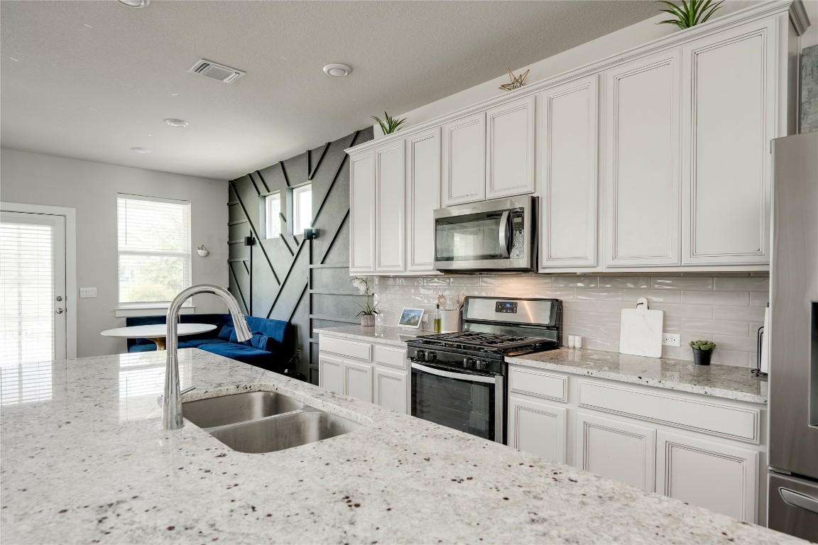 7502 Chesapeake Rail Lane, Unit 154 Austin, TX 78744 - Photo 8 of 40 a kitchen with granite countertop a sink a stove and cabinets