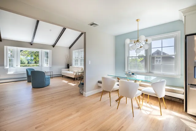 a dining room with furniture window wooden floor and a chandelier