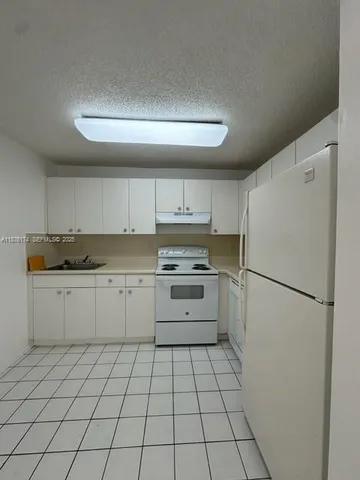 a kitchen with cabinets and white appliances