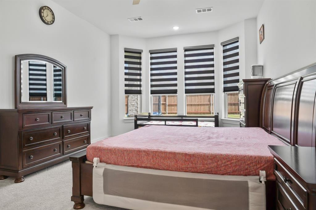 1255 Sumner Street Aubrey, TX 76227 - Photo 12 of 40 a bedroom with a bed and a dresser