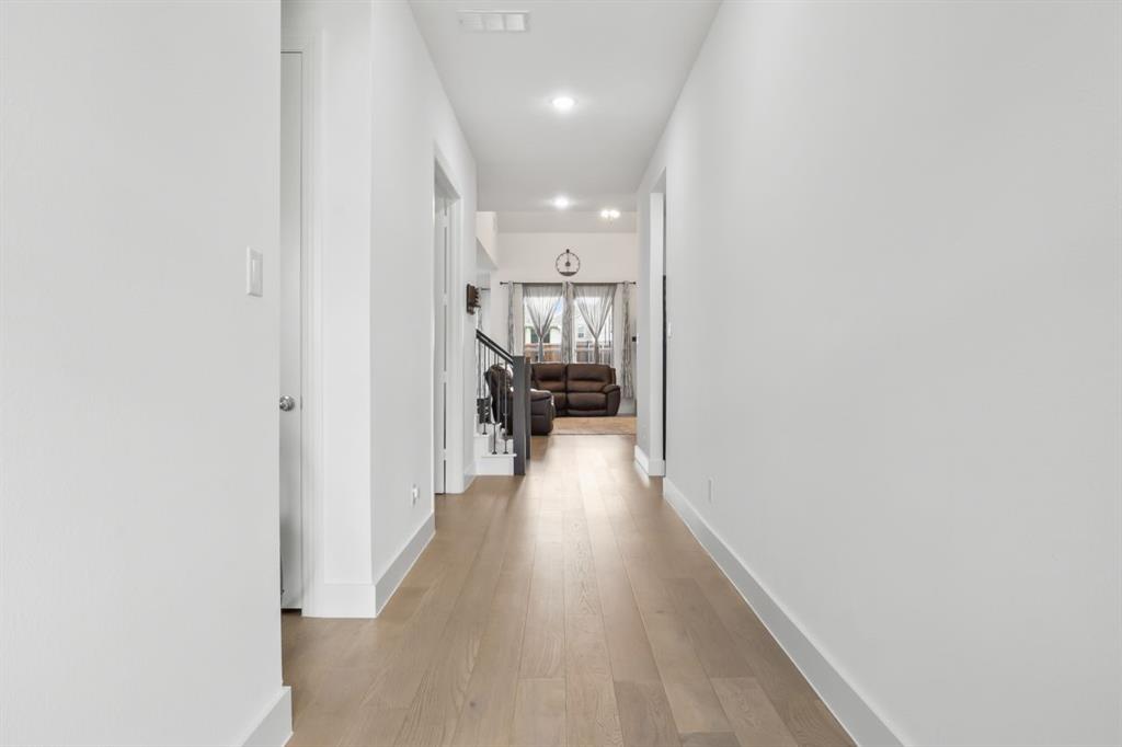 1255 Sumner Street Aubrey, TX 76227 - Photo 18 of 40 a view of a hallway with wooden floor and a bathroom