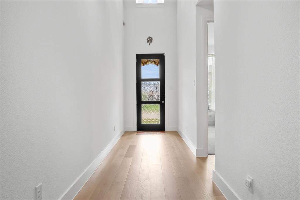 1255 Sumner Street Aubrey, TX 76227 - Photo 2 of 40 a view of a hallway with wooden floor and a window