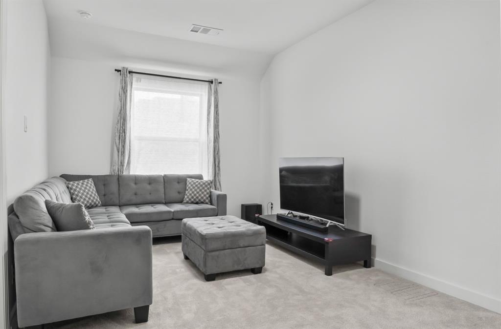 1255 Sumner Street Aubrey, TX 76227 - Photo 25 of 40 a living room with furniture and a flat screen tv