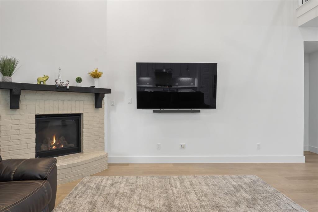 1255 Sumner Street Aubrey, TX 76227 - Photo 4 of 40 a living room with a fireplace and a flat screen tv