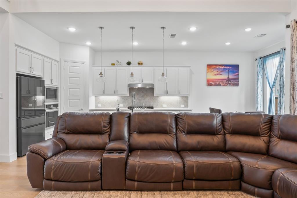 1255 Sumner Street Aubrey, TX 76227 - Photo 6 of 40 a large living room with a couch and a view of kitchen