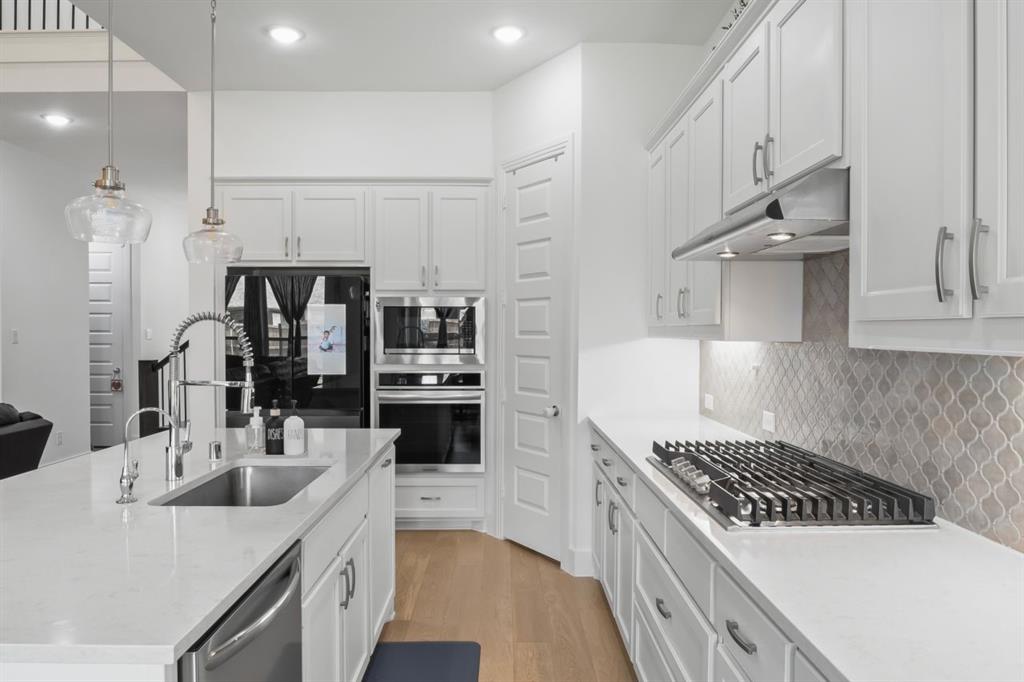 1255 Sumner Street Aubrey, TX 76227 - Photo 8 of 40 a kitchen with stainless steel appliances a sink stove and cabinets