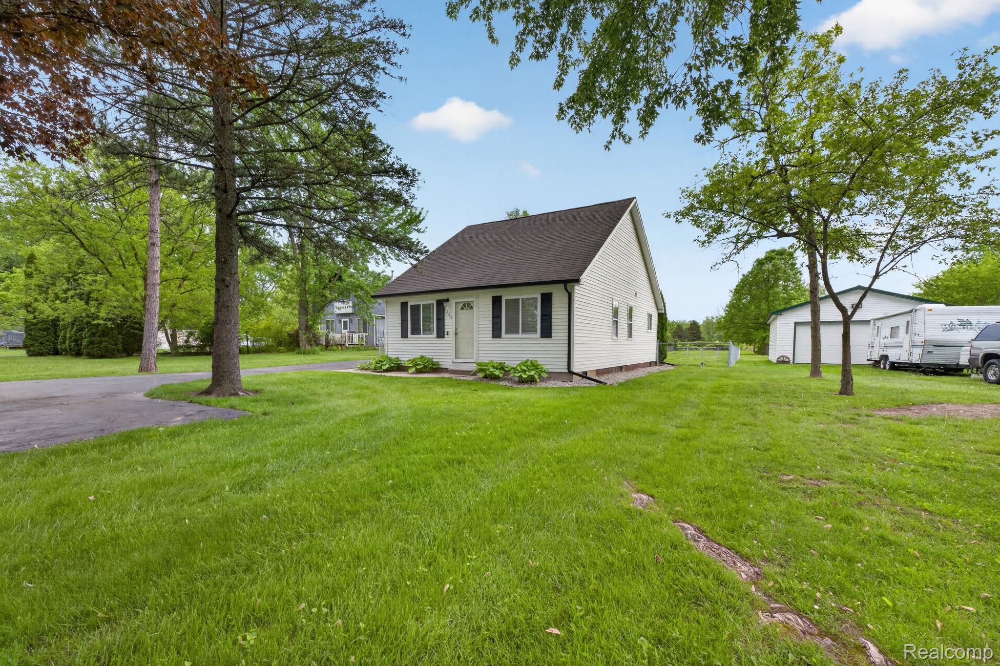 View of front of property featuring a front yard and a shingled roof
