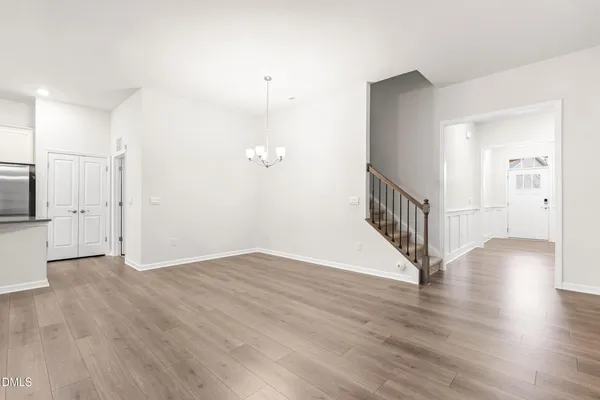 a view of an empty room with a kitchen and fireplace