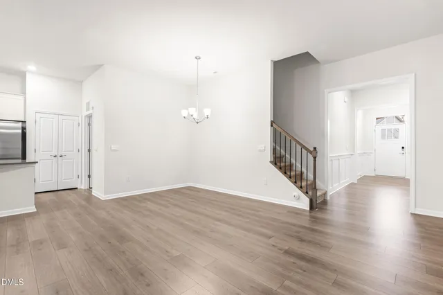 a view of an empty room with a kitchen and fireplace