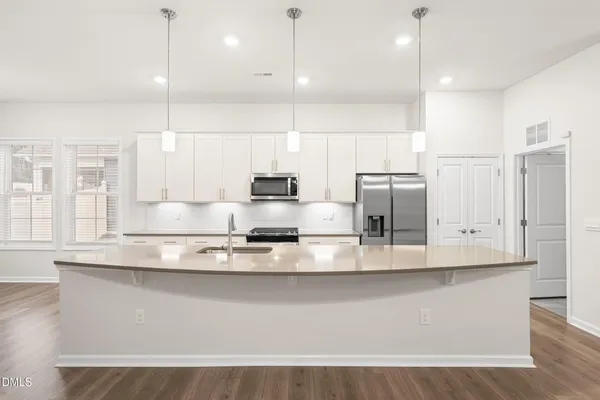 a kitchen with stainless steel appliances granite countertop a sink a stove and a refrigerator