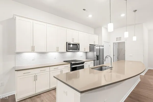 a kitchen with stainless steel appliances granite countertop a sink a stove and a refrigerator