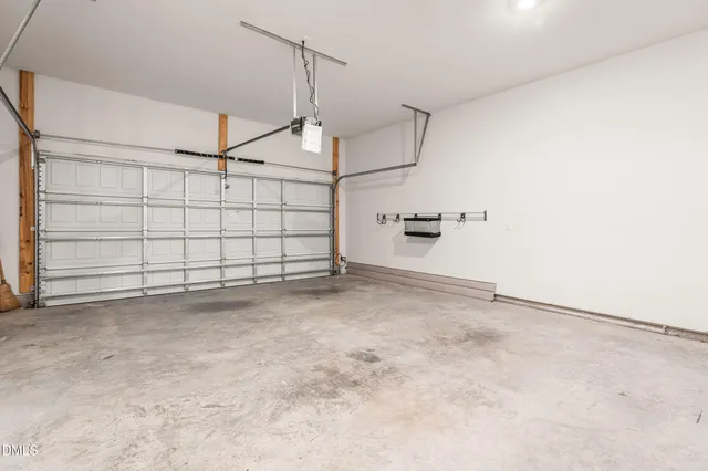 an empty room with wooden floor chandelier fan and windows