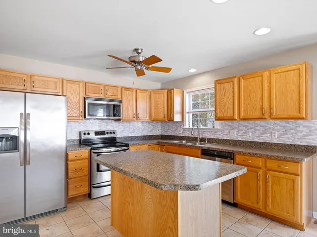 a kitchen with stainless steel appliances granite countertop a sink a stove and a refrigerator